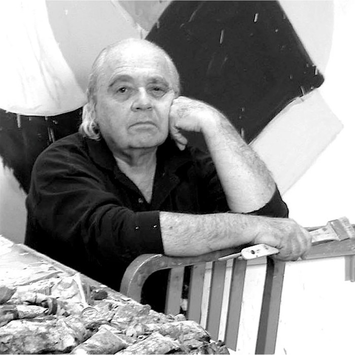 Geoffrey Moss at his worktable, surrounded by paintings and brushes