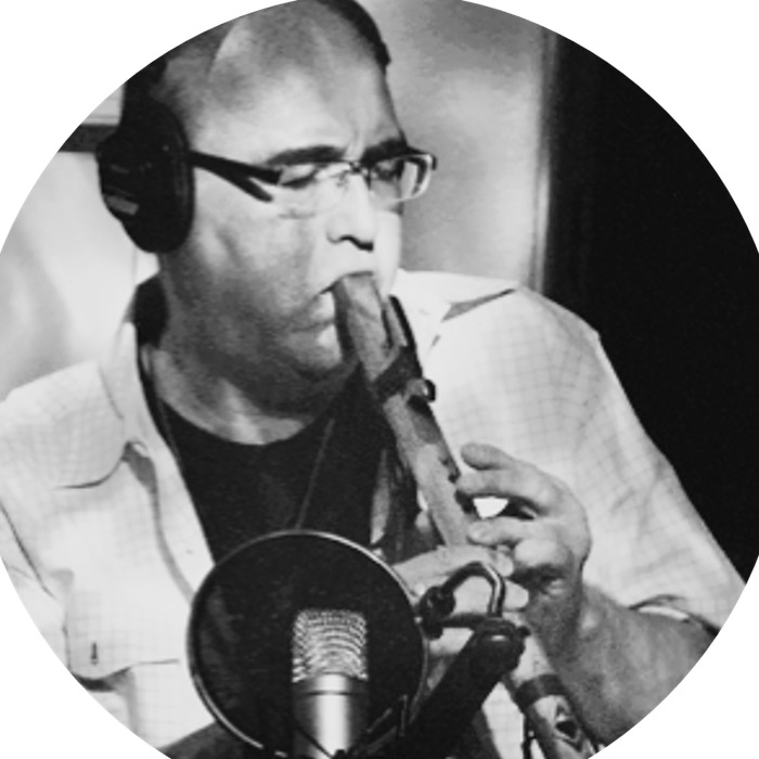 Michael Tamburello playing a wooden flute at a studio microphone