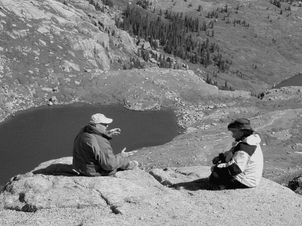 Robert L. Lindstrom and Phil Lawson in conversation on a rock ledge above Summit Lake